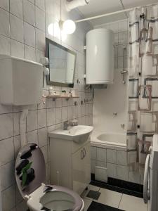 a white bathroom with a toilet and a sink at Genex 37 in Novi Beograd