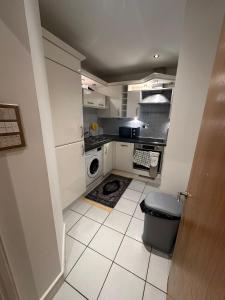 una pequeña cocina con lavadora y secadora. en Cozzy Stay, en Londres