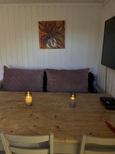 a wooden table with two candles and a couch at Holiday Appartement in Brevik in Porsgrunn