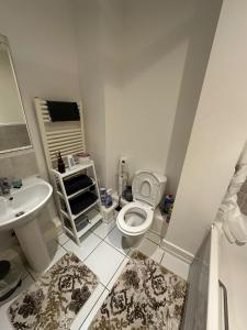 Baño blanco con aseo y lavamanos en Cozzy Stay, en Londres