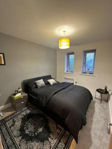 a bedroom with a large bed with a black comforter at Cozzy Stay in London