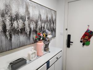 Damac Hills Cozy Studio Apartment في دبي: شخص يرتب الزهور في مزهرية على منضدة المطبخ