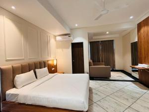 Hotel Saaj Mansion في جايبور: غرفة نوم بسرير ابيض في غرفة