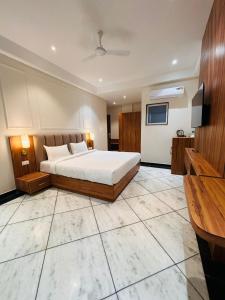 Hotel Saaj Mansion في جايبور: غرفة نوم كبيرة بها سرير وتلفزيون