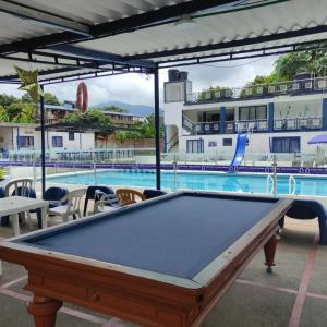 uma mesa de bilhar em frente a uma piscina em Hotel Marqués de San Luis em Melgar