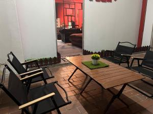 een patio met een houten tafel en stoelen bij Hanna homestay studio in Alor Setar