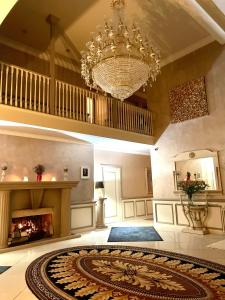 ein großes Wohnzimmer mit einem Kronleuchter und einem Kamin in der Unterkunft FINN VILLAGE – Loch Lomond Luxury Lodges with All Year-Round Hot Tubs and Gazebos in Glasgow