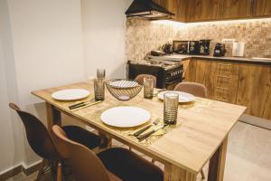 Καλλιστώ apartments في نافبليو: مطبخ مع طاولة خشبية عليها لوحات