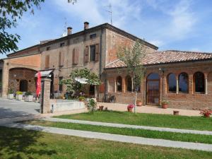 un grande edificio in mattoni con un marciapiede di fronte di Hotel La Cascina a Fontanellato