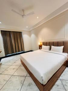Un dormitorio con una cama grande y una ventana en Hotel Saaj Mansion en Jaipur