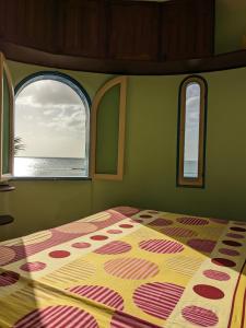 a bedroom with a bed and two windows with the ocean at Torre Sabina in Vila do Porto