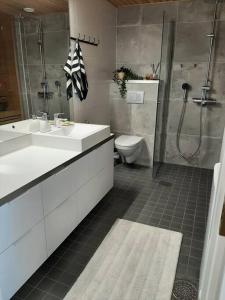 y baño con 2 lavabos, ducha y aseo. en Upea kaksio Näsijärven rannalla en Tampere