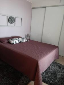 um quarto com uma cama roxa e 2 almofadas em Upea kaksio Näsijärven rannalla em Tampere