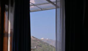 a window with a view of a mountain at PANORAMIC PARADISE in Alwar