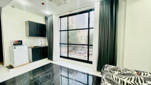 ein Wohnzimmer mit einem großen Fenster und eine Küche in der Unterkunft Ultra muse Studio Apartment in Lahore