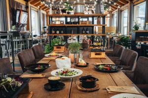 Natur Views, Chaty NATUR RESORT في فيلكا لومنيكا: طاولة خشبية طويلة عليها صحون طعام +26 صورة