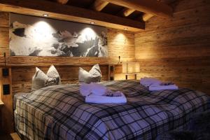 una camera con un letto in una baita di tronchi di Erezsässhütte a Klosters