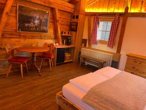Schlafzimmer mit einem Bett, einem Tisch und einem Schreibtisch in der Unterkunft Jägerstübli Grindelwald in Grindelwald