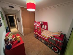 een kinderkamer met een rood bed en een brandweerwagen bij Apartamento turístico 2 hab. in Vera