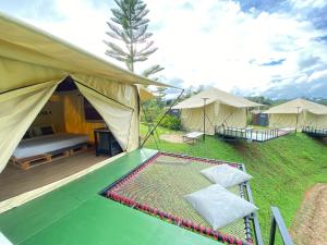 une tente avec un lit et deux chaises dans l'établissement khaokho keree tara, à Khao Kho