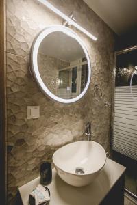 Καλλιστώ apartments في نافبليو: حمام مع حوض ومرآة
