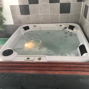 jacuzzi w wyłożonej kafelkami łazience w obiekcie la forge de Clermont w mieście Clermont