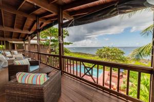 a balcony with chairs and a view of the ocean at Cocolobo Resort in West End