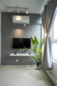 a living room with a tv and a plant at Seaview Mansion One Georgetown in George Town