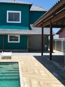 a blue house with a swimming pool in front of it at Faith Home 3 in Arraial do Cabo