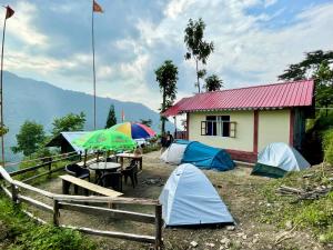 a group of tents pitched in front of a house at Kolakham Hillcrest Homestay in Rishop