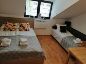 Schlafzimmer im Dachgeschoss mit 2 Betten und einem Tisch in der Unterkunft Apartma Happy in Kranjska Gora