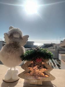 a santa claus toy next to a christmas tree at Blue Sea Apartment in Punta Braccetto