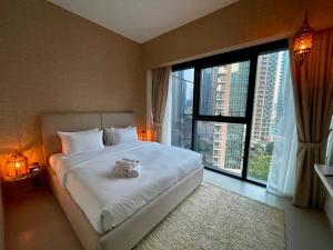 Un dormitorio con una cama con un osito de peluche. en Stylish New 2BR l Spacious with Burj & Fountain Views l near Dubai Mall l Pool l Gym en Dubái