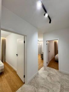 una camera con pareti bianche e un corridoio con una camera da letto di Forest Apart IV a Varsavia
