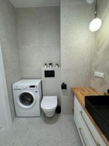 uma casa de banho com uma máquina de lavar roupa e um WC em Forest Apart IV em Varsóvia