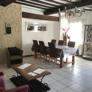 uma sala de jantar com mesa e cadeiras em la forge de Clermont em Clermont