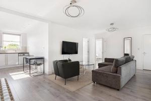 a living room with a couch and chairs and a tv at Superb penthouse with 2 bathrooms and roof terrace in London