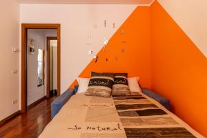 een bed in een kamer met een oranje muur bij Station & Center - Self Check-in & Access in Como