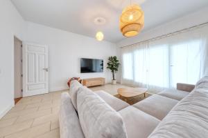 a living room with a large couch and a tv at Mar Azul Puerto Calero in Puerto Calero