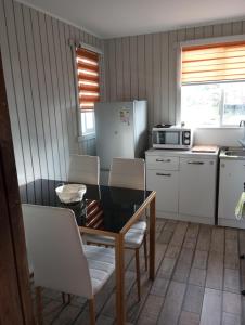 uma cozinha com uma mesa e cadeiras e um frigorífico em Cabañas y Tinajas FERISI em Cochrane
