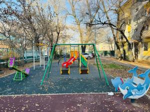 a playground with colorful swings in a park at Infinity Estate MEGA Park in Almaty