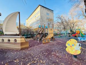 a playground with a slide and a swing set at Infinity Estate MEGA Park in Almaty