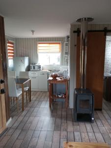 a kitchen with a stove in the middle of a room at Cabañas y Tinajas FERISI in Cochrane