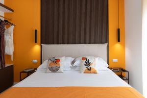 1 dormitorio con 1 cama blanca y paredes de color naranja en Citrus Home, en Meta