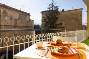 una mesa con 2 platos de comida en el balcón en Citrus Home, en Meta