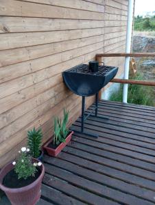 a barbecue grill on a wooden deck with plants at Cabañas y Tinajas FERISI in Cochrane