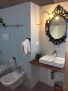 La salle de bains est pourvue d'un lavabo, d'un miroir et de toilettes. dans l'établissement B&B Casa del Nonno, à Adrara San Rocco