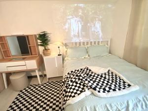 um quarto com uma cama e uma televisão em white room private bathroom Red Panda Guesthouse em Seul
