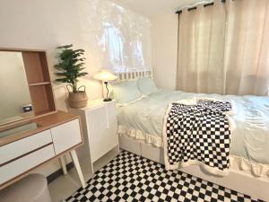 una camera con letto, cassettiera e specchio di white room private bathroom Red Panda Guesthouse a Seul
