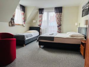une chambre d'hôtel avec deux lits et un canapé dans l'établissement Willa Gronicka, à Białka Tatrzańska